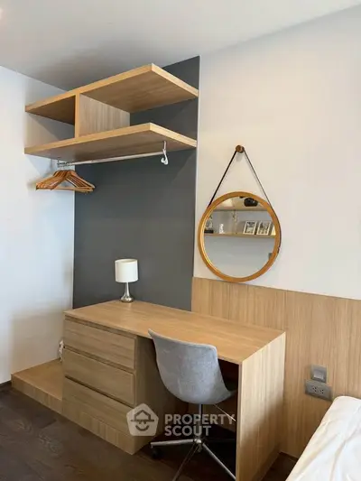 Modern study area with wooden desk, shelves, and stylish mirror in a cozy apartment.