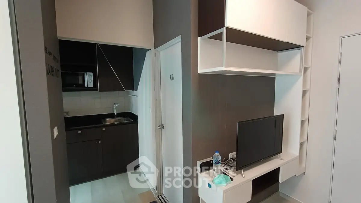 Modern compact living space with sleek kitchen and entertainment area