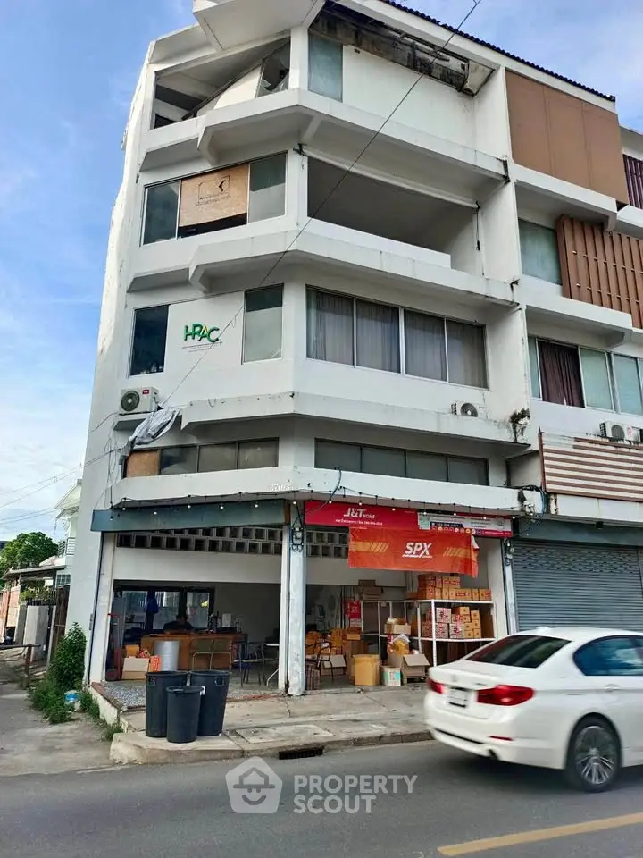 Commercial building with retail space on ground floor and residential units above.