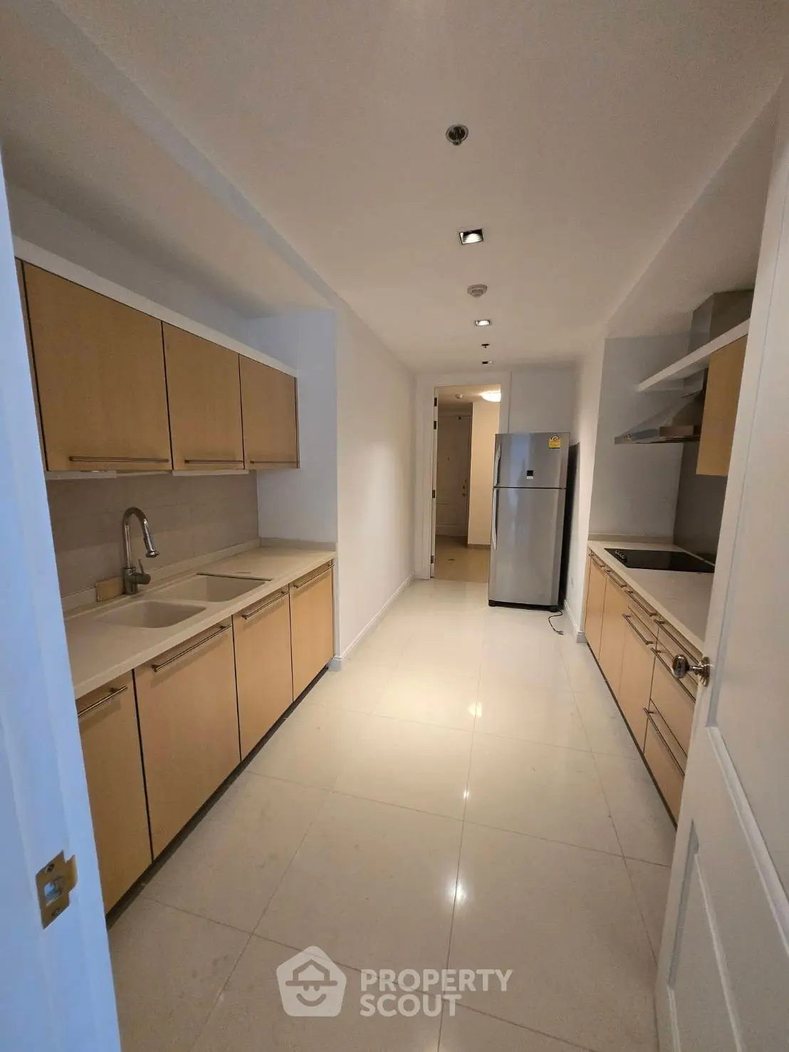Modern kitchen with sleek cabinetry and stainless steel appliances in a spacious apartment.