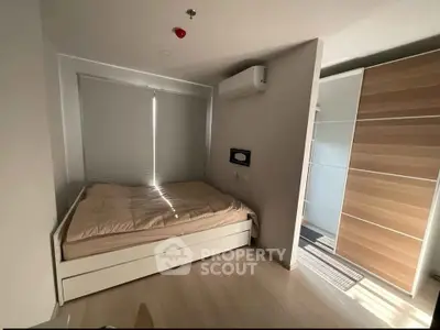 Modern bedroom with sleek design, featuring a cozy bed and ample natural light, perfect for urban living.