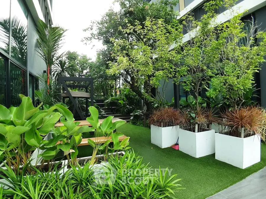 Lush garden area with modern landscaping and seating in a residential complex.