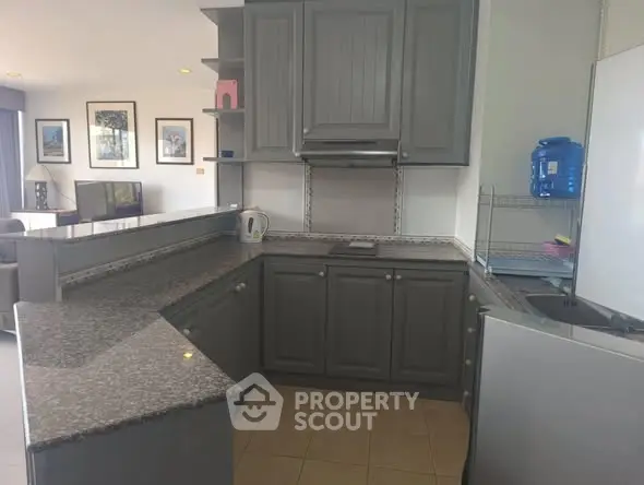 Spacious kitchen with granite countertops and open layout in modern apartment.