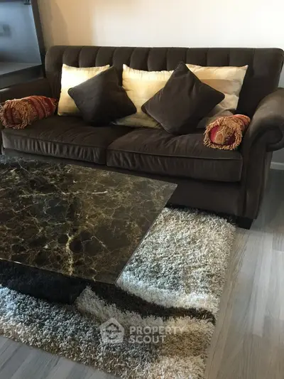 Cozy living room with plush brown sofa and elegant marble coffee table on a stylish rug.