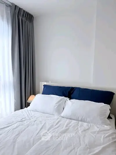 Cozy bedroom with elegant white bedding and soft lighting, perfect for relaxation and comfort.