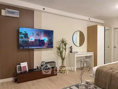 Modern living room with stylish decor and wall-mounted TV, perfect for relaxation and entertainment.