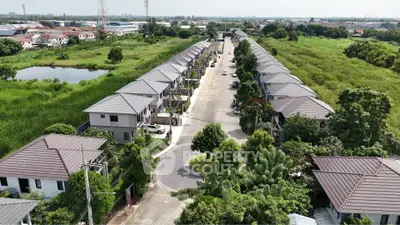 Aerial view of modern residential housing complex with lush greenery and spacious layout.