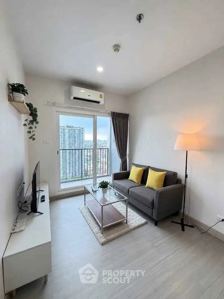 Modern living room with city view, featuring sleek furniture and large windows for natural light.