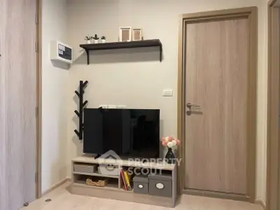 Modern living room corner with TV, stylish shelf, and decorative accents.