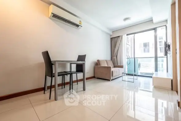 Modern living room with sleek furniture and balcony access.