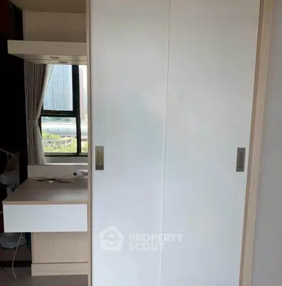 Modern bedroom with built-in wardrobe and city view window