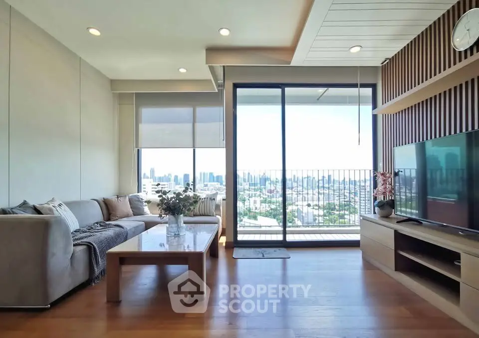Spacious living room with city view and modern decor, featuring a large balcony.