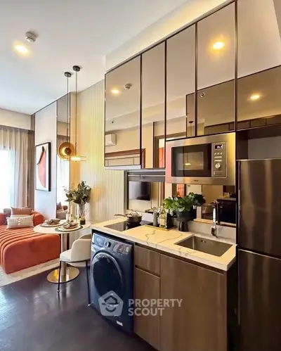 Modern kitchen with sleek appliances and open layout in stylish apartment.