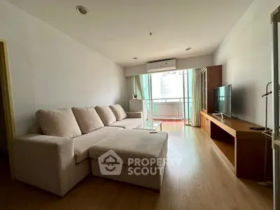 Spacious living room with modern sofa and large TV, perfect for relaxation.