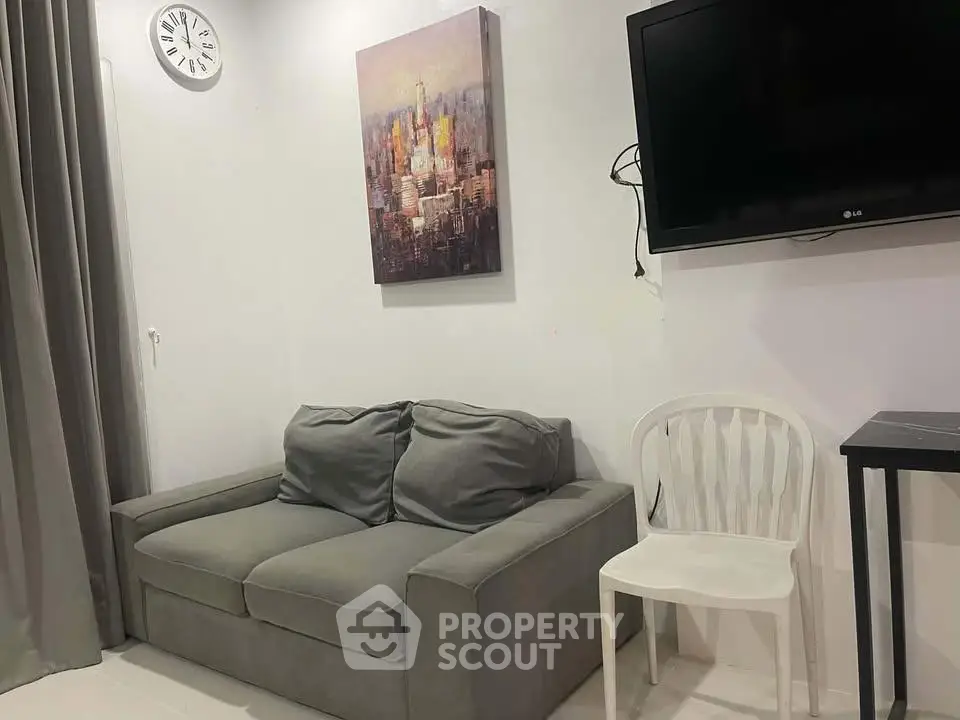 Cozy living room with modern decor, featuring a comfortable sofa, wall-mounted TV, and stylish artwork.