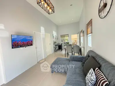 Modern living room with stylish decor and wall-mounted TV in a bright, open space.