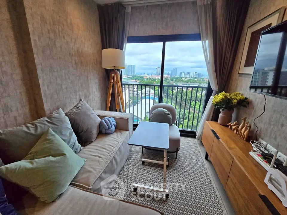 Chic living room with cozy sofa, modern decor, and stunning city view from balcony.