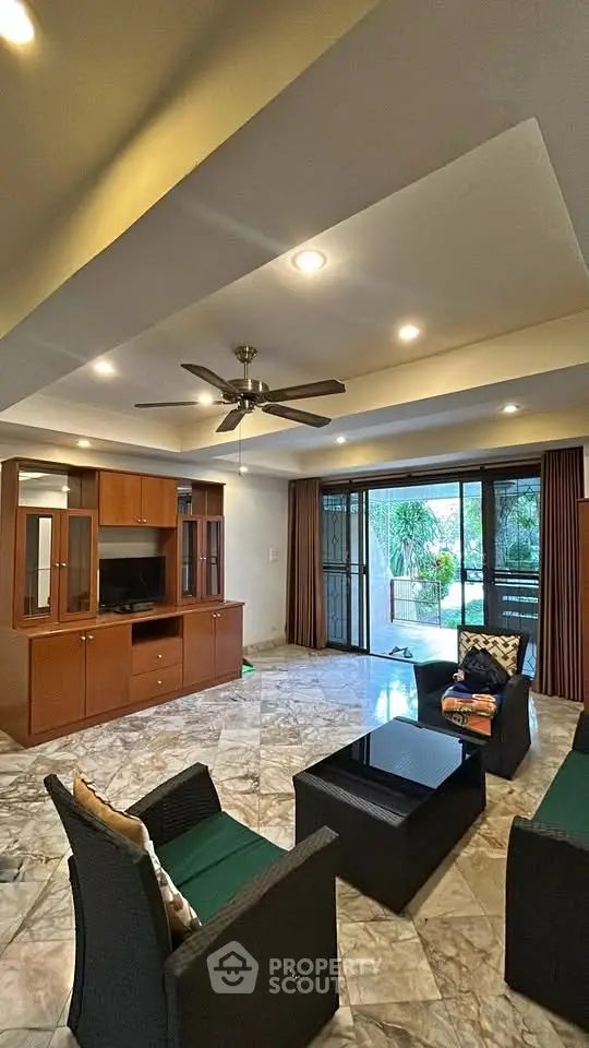 Spacious living room with modern furniture and garden view, perfect for relaxation and entertainment.