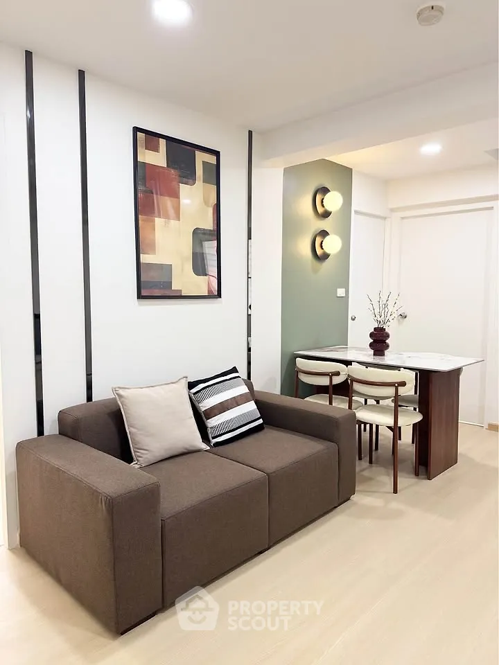 Modern living room with stylish sofa and dining area in open layout apartment.