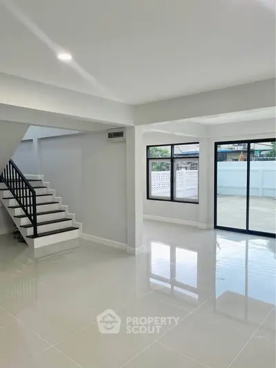 Spacious modern living room with glossy tile floors and large windows