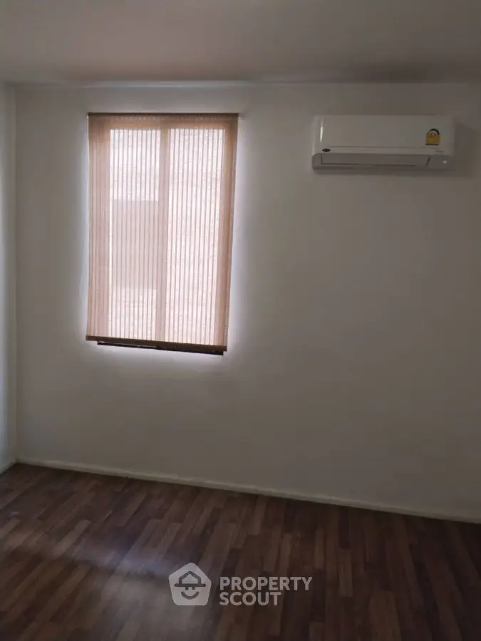 Minimalist room with air conditioner and wooden floor, perfect for cozy living.