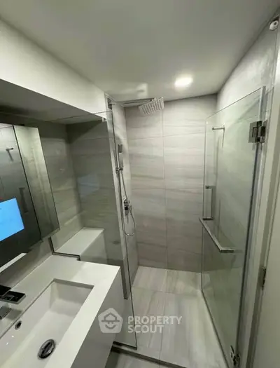 Modern bathroom with sleek shower and stylish vanity in contemporary apartment.