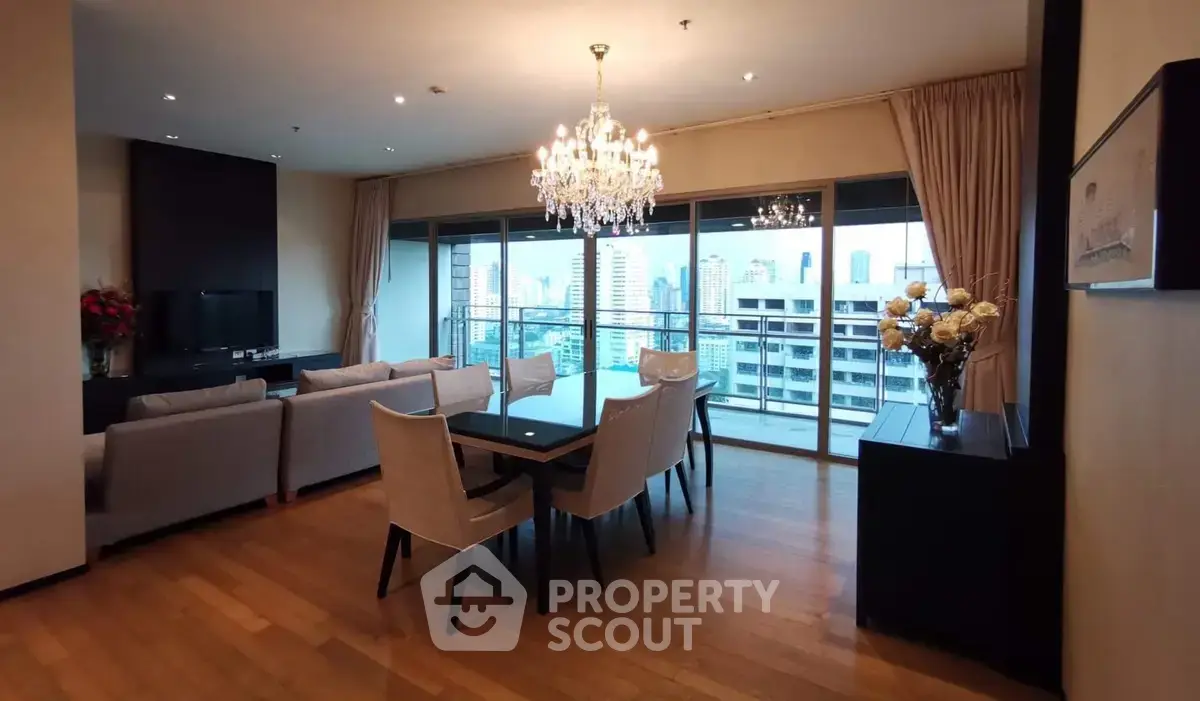 Luxurious living room with chandelier and city view, featuring elegant dining area and spacious seating.