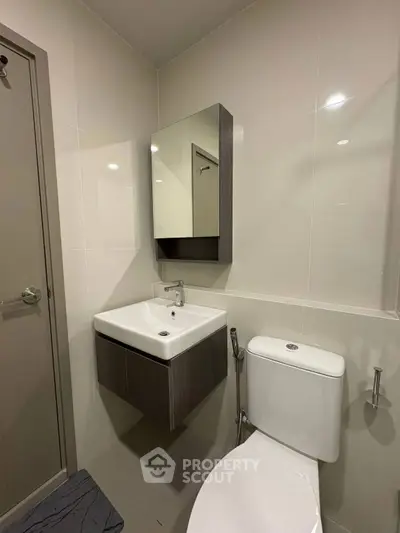 Modern bathroom with sleek fixtures and wall-mounted sink in a contemporary apartment.