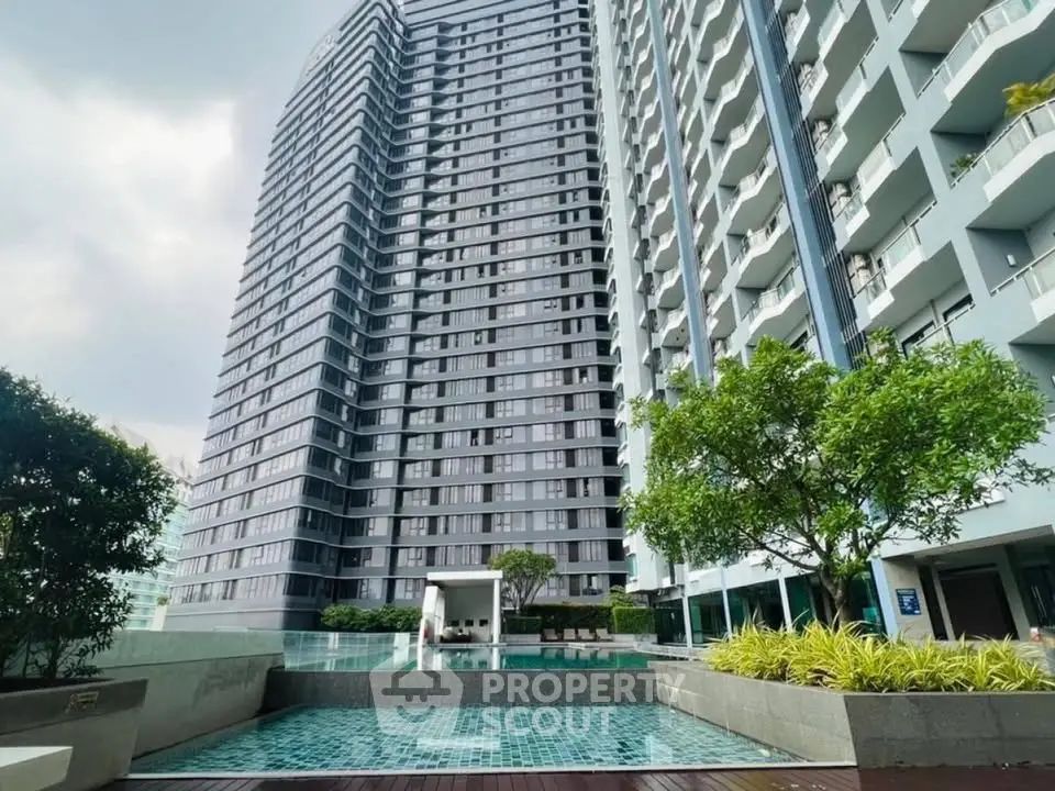 Modern high-rise building with pool and lush greenery, perfect for urban living.