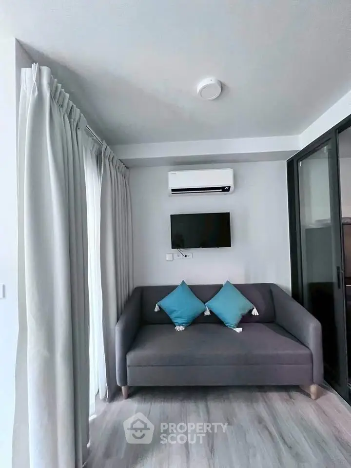 Cozy living room with modern sofa and air conditioning, perfect for relaxation.
