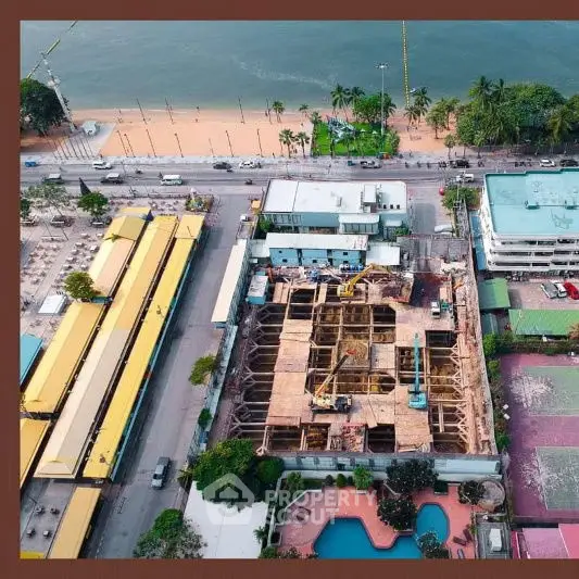 Aerial view of beachfront construction site with pool and ocean view.