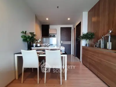 Modern dining area with sleek wooden cabinetry and elegant table setting in a stylish apartment.
