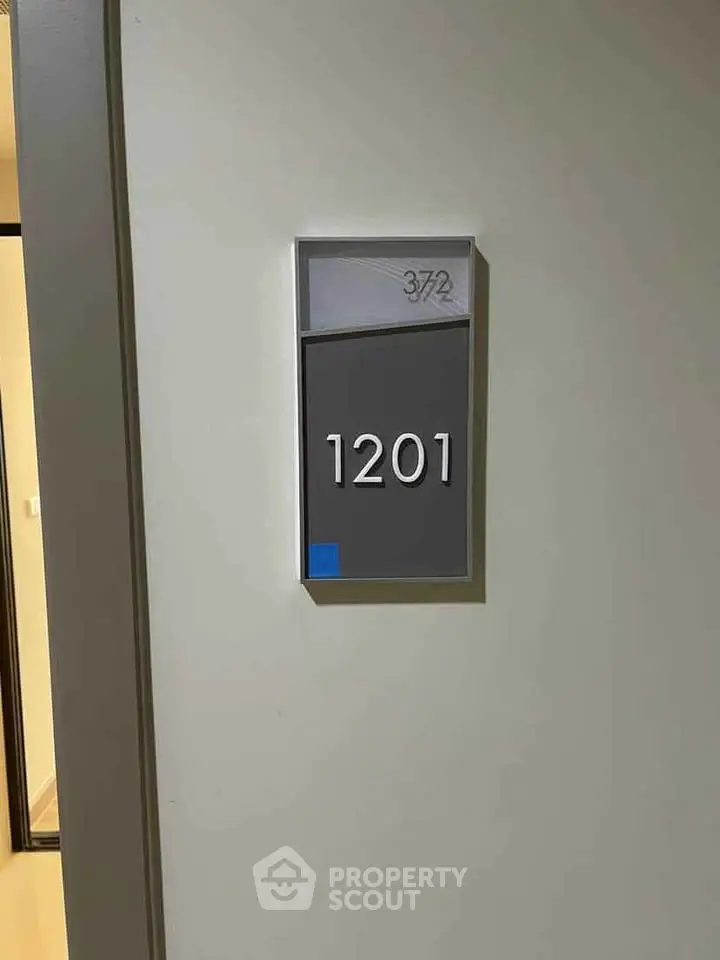 Modern apartment door with unit number 1201, sleek design and neutral colors.