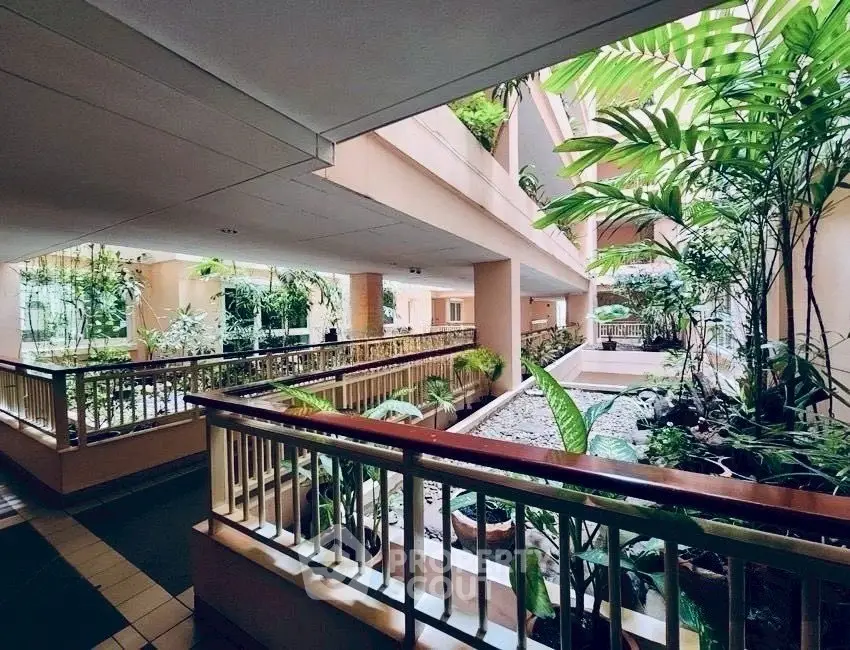 Luxurious building interior with lush greenery and modern design, offering a serene and inviting atmosphere.