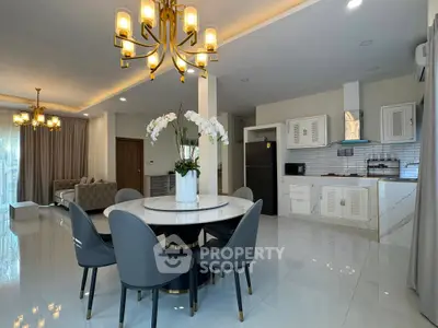 Luxurious open-plan living and dining area with elegant chandeliers and modern kitchen.