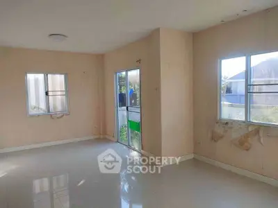 Spacious unfurnished room with large windows and tiled floor, ideal for customization.