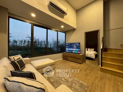 Modern living room with large windows and cozy seating area