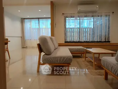 Spacious modern living room with elegant furniture and large windows for natural light.