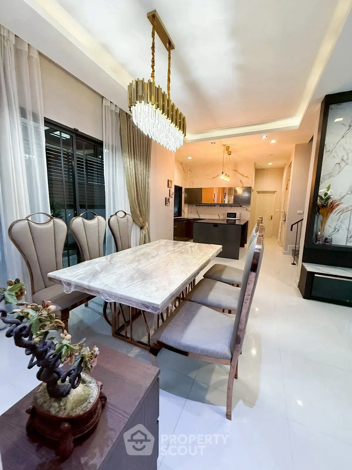 Elegant dining area with luxurious chandelier and modern kitchen in open layout