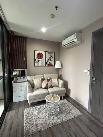 Cozy modern living room with stylish decor and air conditioning in a compact apartment.