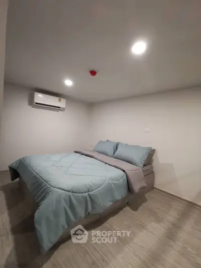 Cozy bedroom with modern decor and air conditioning, perfect for relaxation.
