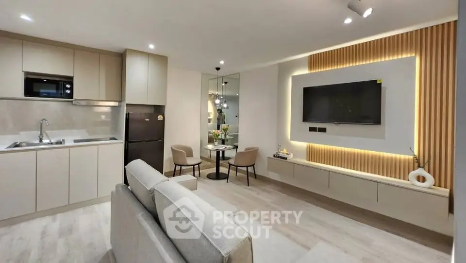 Modern open-plan living room and kitchen with sleek design and ambient lighting.