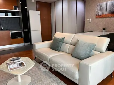 Modern living room with sleek furniture and open kitchen layout in stylish apartment.
