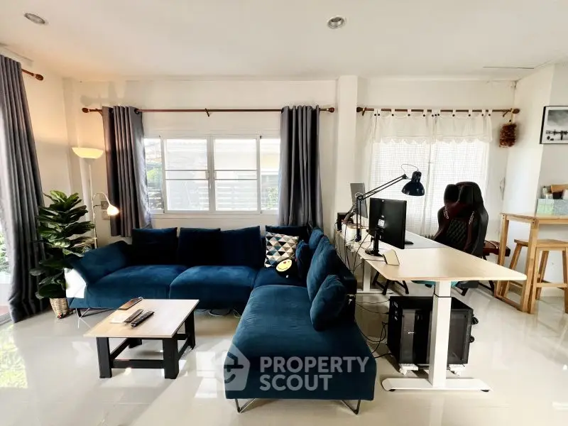 Modern living room with blue sectional sofa and home office setup
