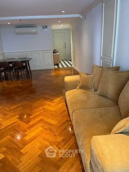 Spacious living room with elegant wooden flooring and cozy sofa, perfect for relaxation and entertaining guests.