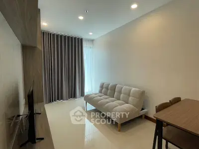 Modern living room with sleek furniture and natural light, perfect for relaxation and entertainment.