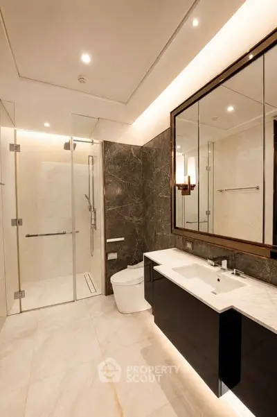 Luxurious modern bathroom with marble finishes and glass shower enclosure