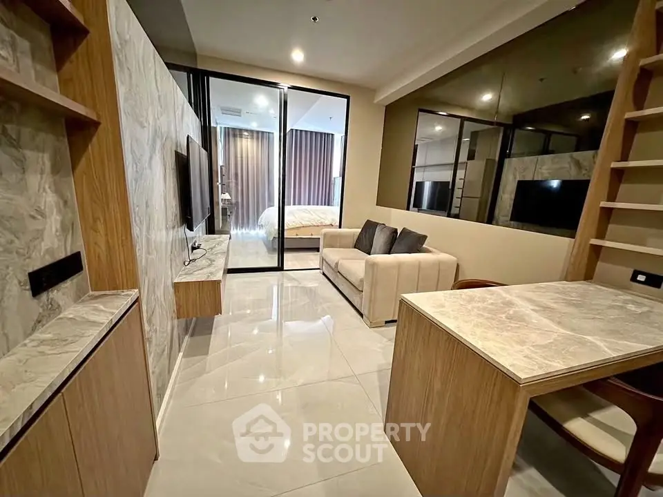 Modern open-plan living room with sleek marble accents and cozy seating area