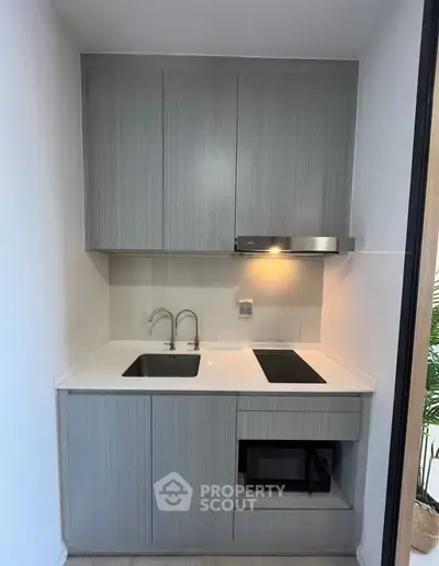 Modern compact kitchen with sleek cabinetry and built-in appliances, perfect for urban living.