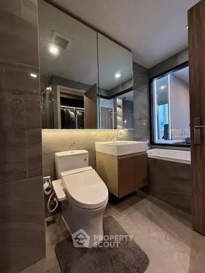 Modern bathroom with sleek fixtures and large mirror in luxury apartment.